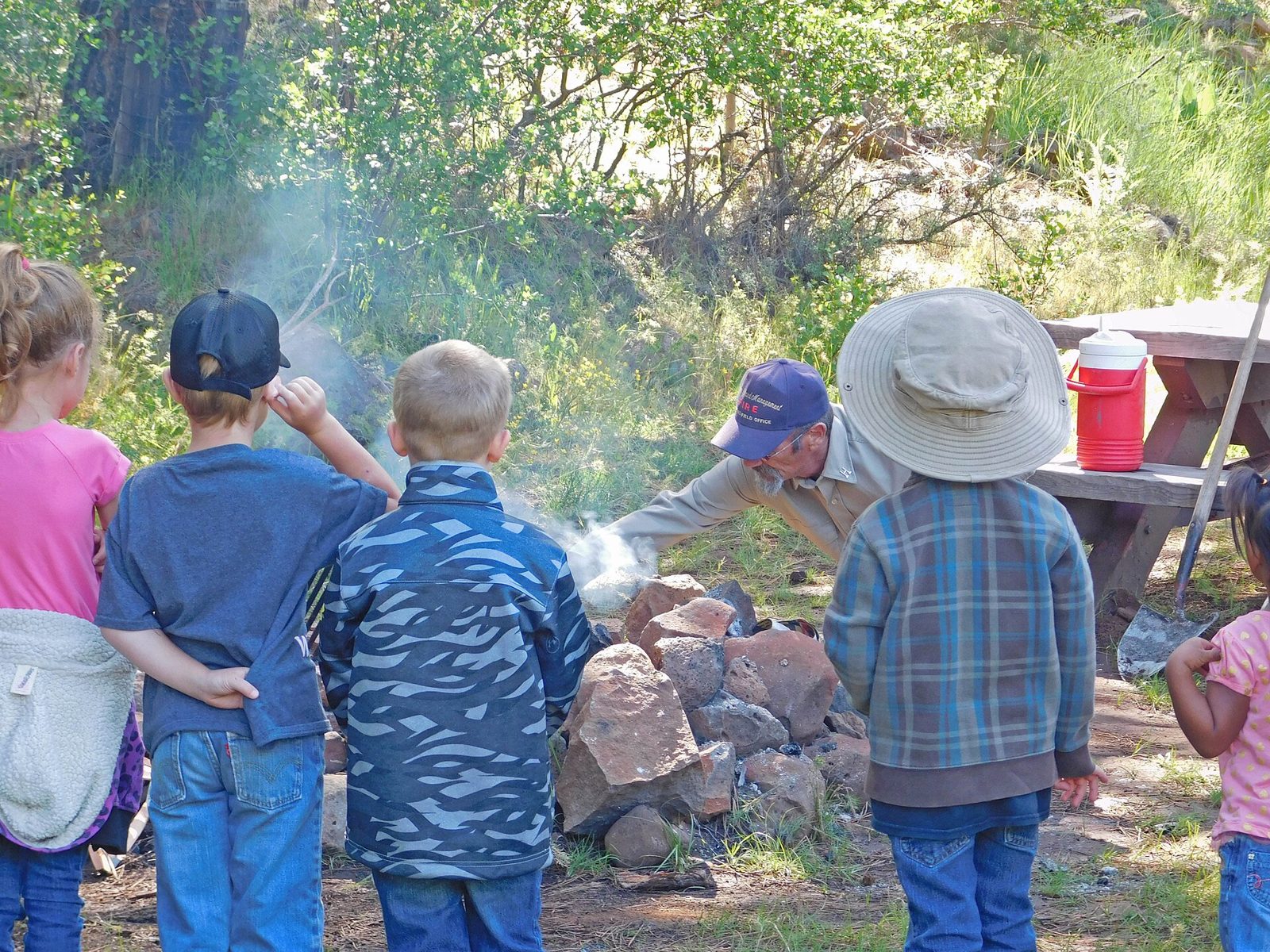 Kids in a circle with a leader during a nature program outdoors