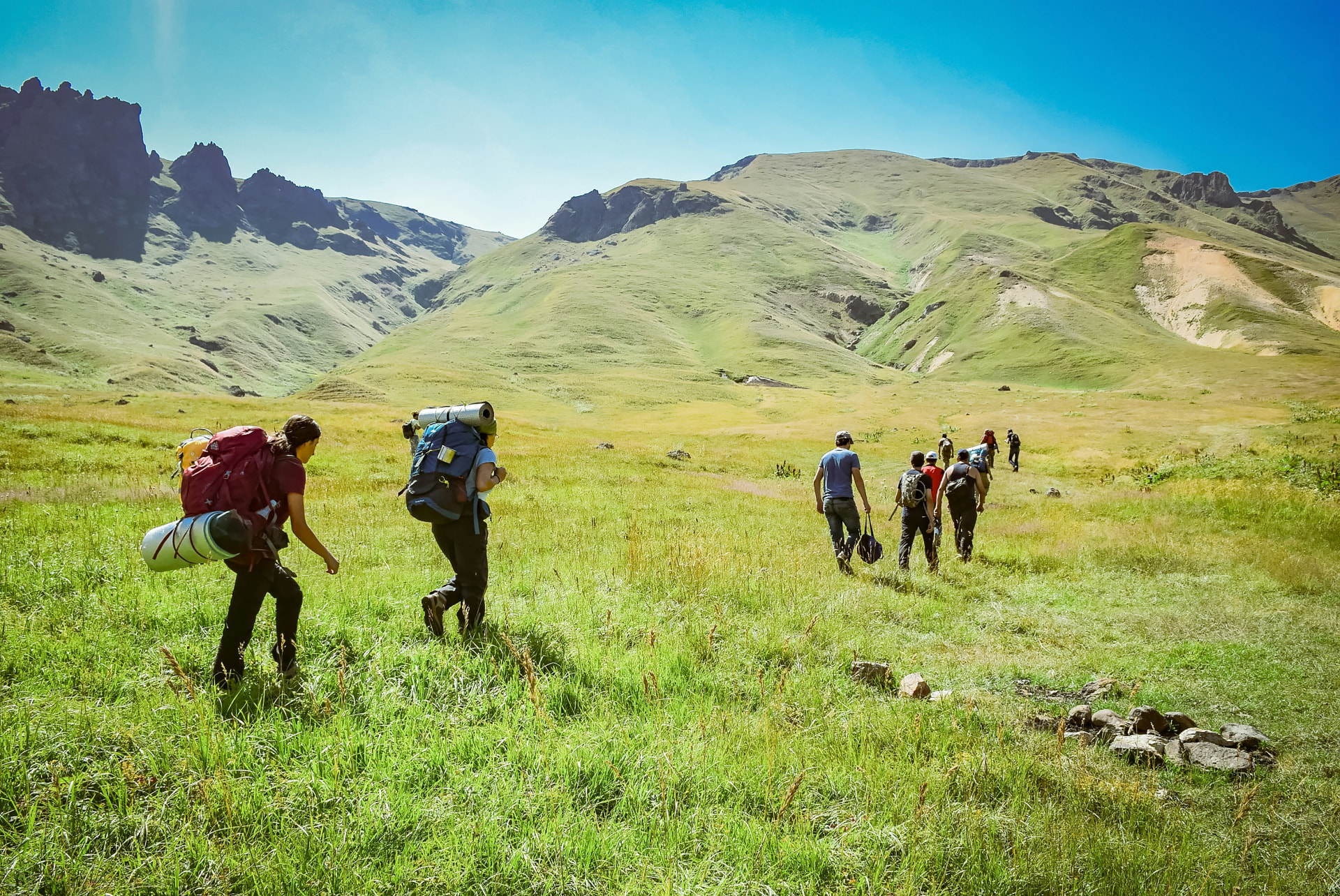 Hikers exploring a sunlit mountain valley