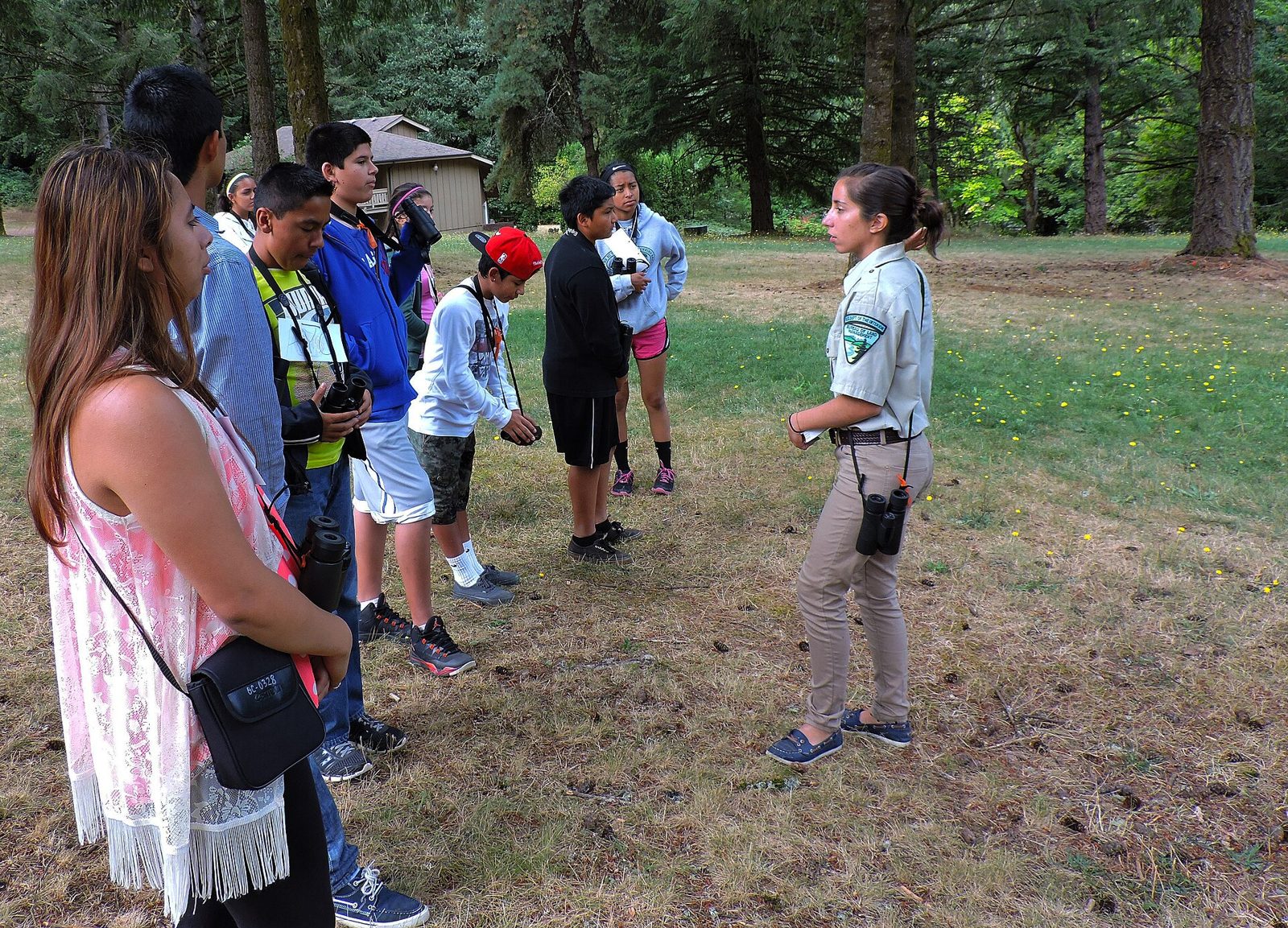 Outdoor educator leading a group of kids in a wooded park