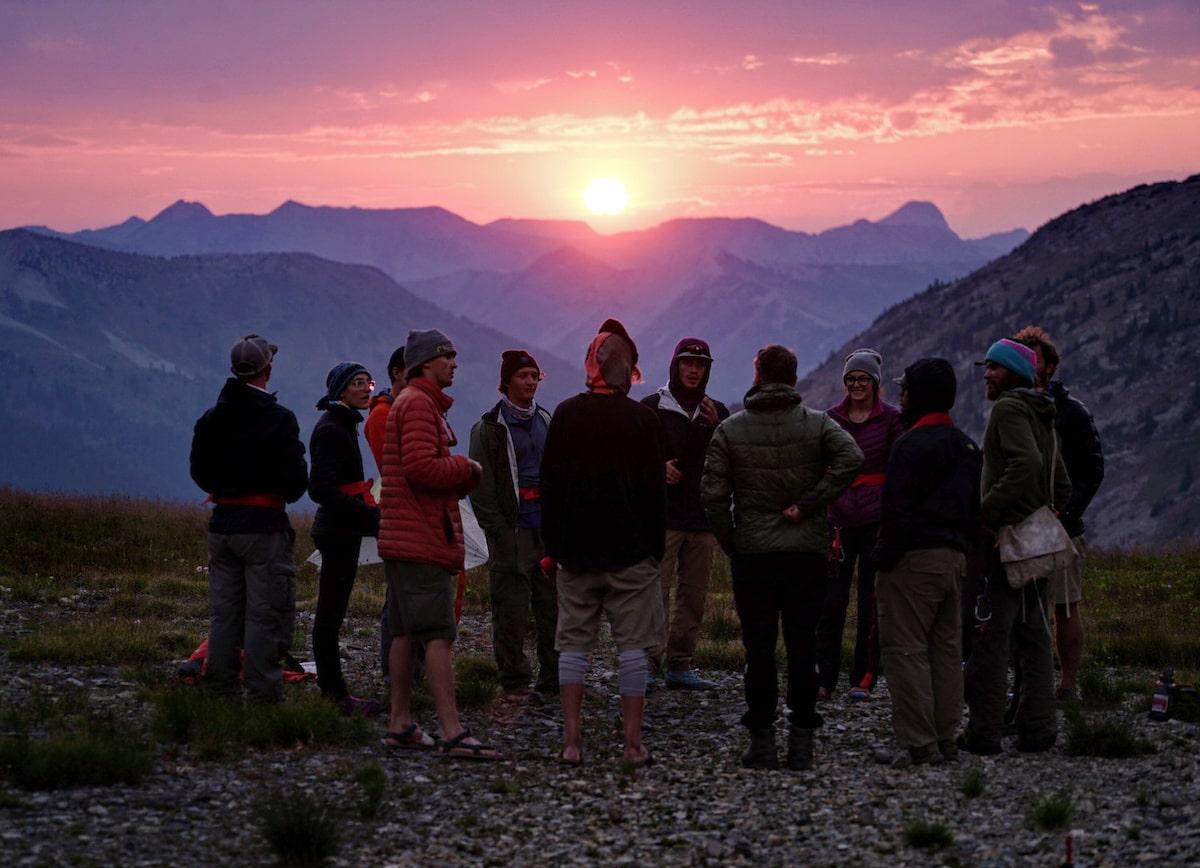 Outdoor group gathered in the mountains at sunset