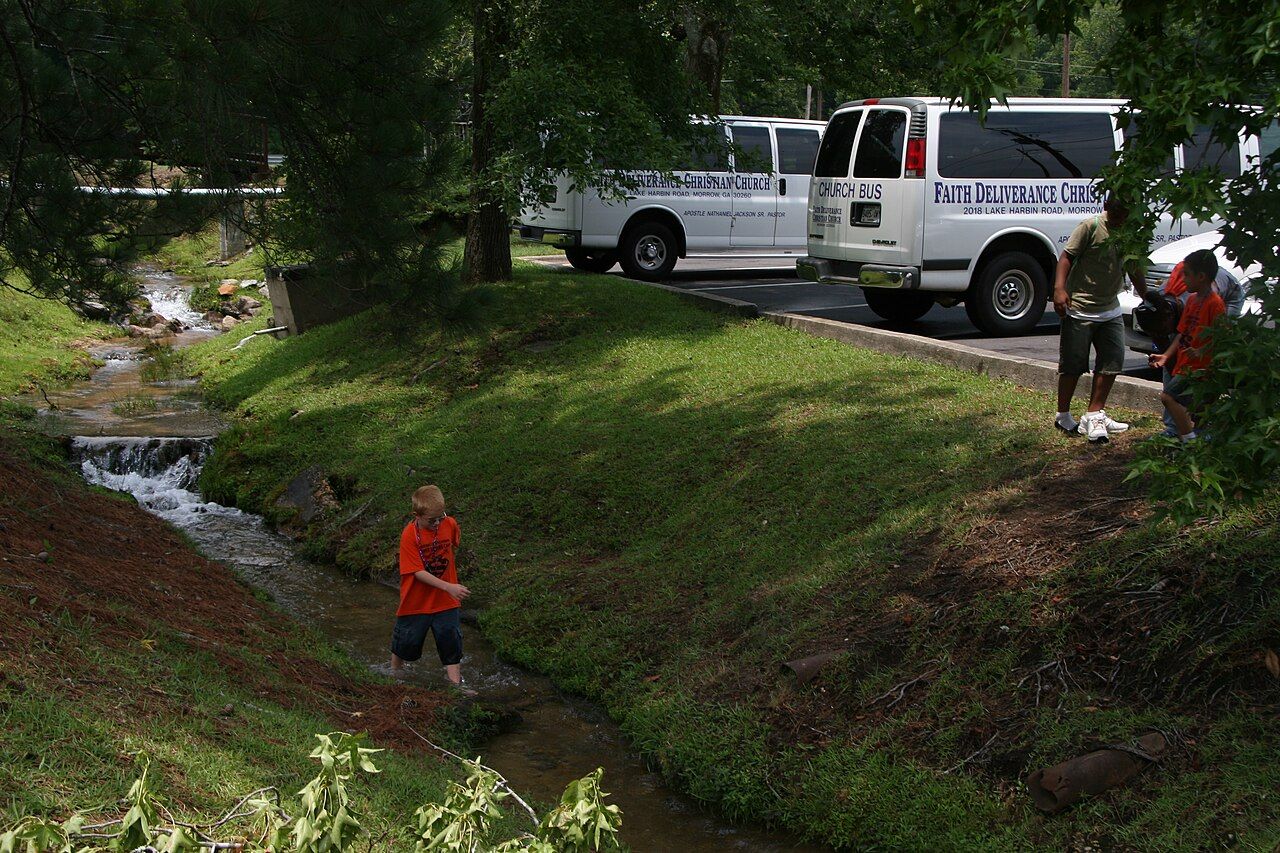 Young camper exploring a creek looking for wildlife